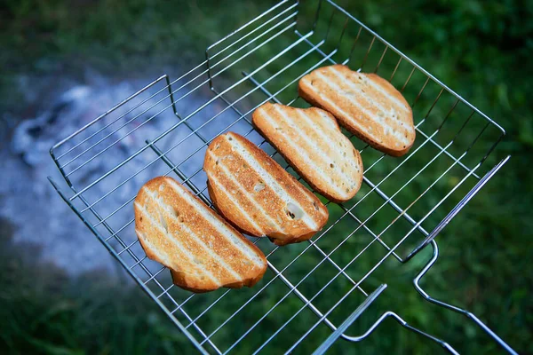 Grilled toast on the wire rack. Outdoor recreation. Bonfire, grill, delicious