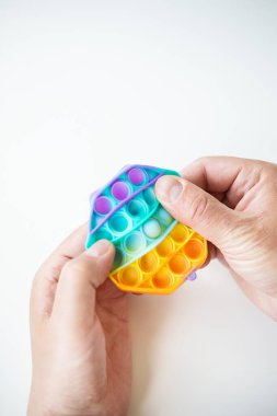 The most fashionable sensory toy. Popular fashion silicone colorful anti-stress hexagonal pop it toy. Someone presses on a silicone toy. A trendy toy for children