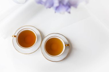 İki fincan siyah çay porselen bir fincanda altın kesikli güzel bir beyaz fincan. Çay töreni konsepti