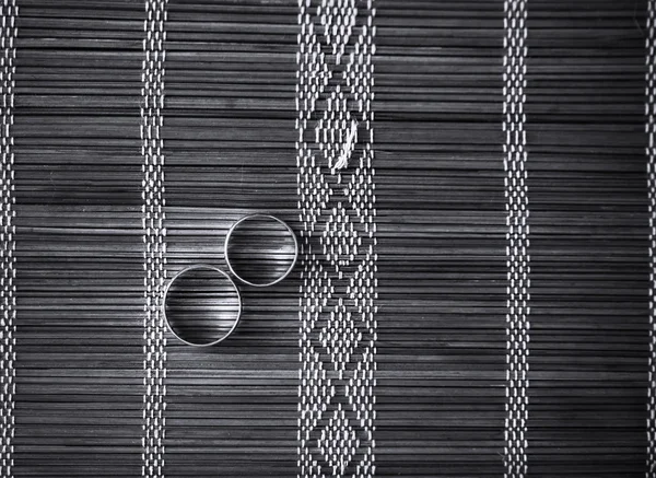 Два обручальных кольца на бамбуковом коврике — стоковое фото
