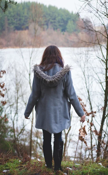 Giovane ragazza con i capelli si trova vicino all'acqua — Foto Stock