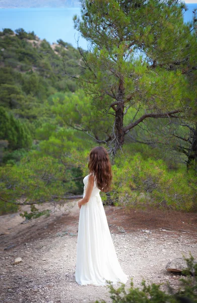 Schönes Mädchen trägt weißes fließendes Kleid im Wald — Stockfoto