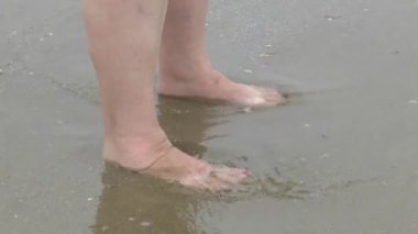 Deniz kıyısı üzerinde yürüyen kadın