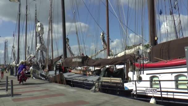 People pass by сharter ships on a quay — Stock Video