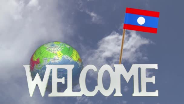 Turning globe and small paper flag of LAOS — Stock Video