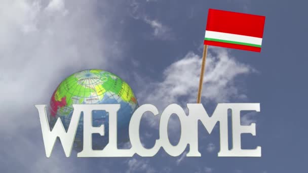 Вращающийся глобус и маленький бумажный флаг Тадзикистана — стоковое видео