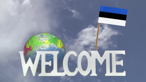 Поворотний глобус і невелику паперову прапор Естонії — стокове відео