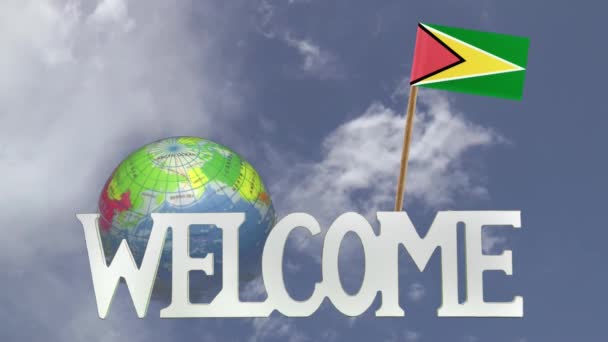 Draaiende globe en kleine papieren vlag van Guyana — Stockvideo