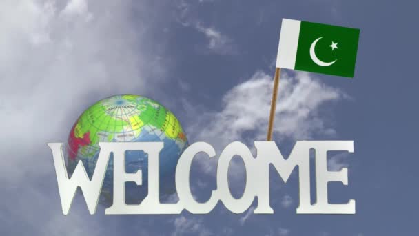 Turning globe and small paper flag of PAKISTAN — Stock Video