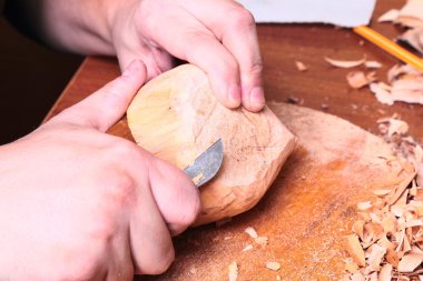 Marangoz eli odun oyuyor.