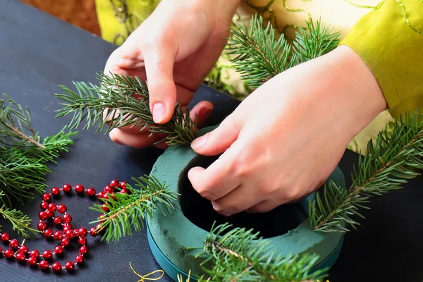 Mujer haciendo corona de Navidad — Foto de Stock