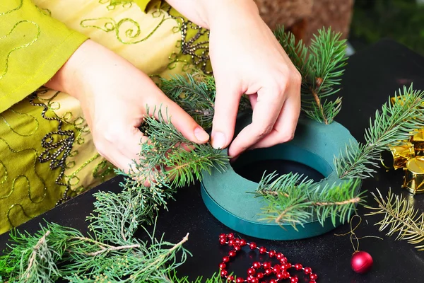 Vrouw die kerstkrans maakt — Stockfoto