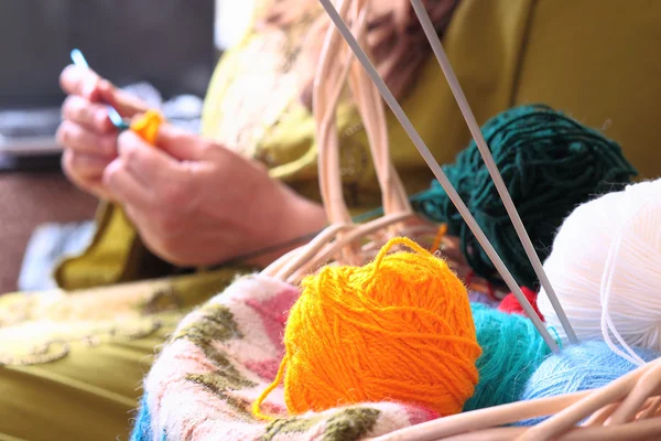 Basket with balls of yarn  and woman knitting — Stock Photo, Image