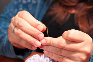 Kadın bir iğne iplik için çalışıyor