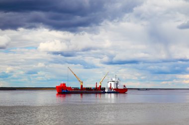 Kargo gemisi nehirde yol alıyor.