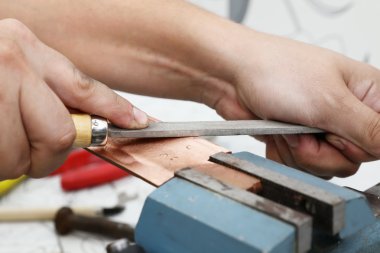 Bakır kütük bir dosyayla taşlama