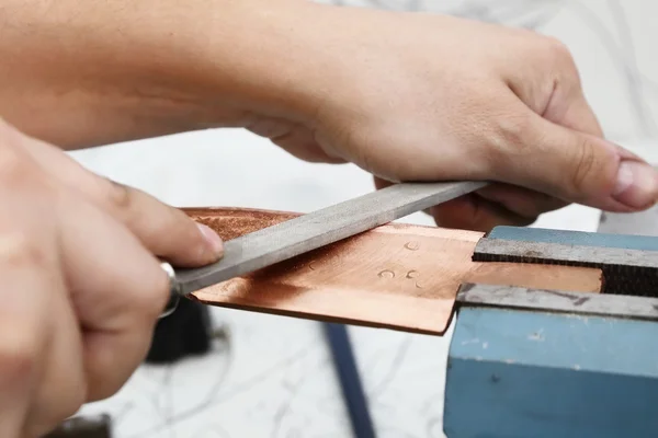 Grinding the copper billet with a file — Stock Photo, Image