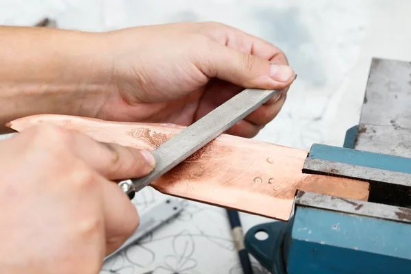 Grinding the copper billet with a file — Stock Photo, Image