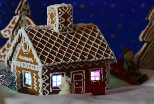 Biglietto natalizio con casa di pan di zenzero piccolo pupazzo di neve — Foto Stock