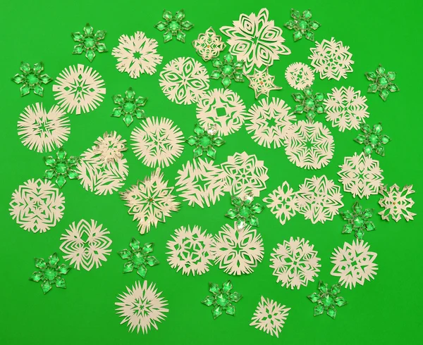 Flocos de neve sobre papel verde — Fotografia de Stock