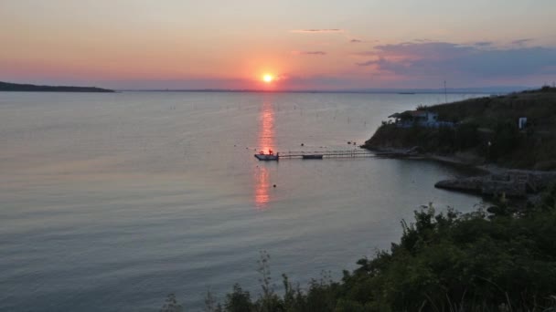 Güneş, ev ve İskele ile deniz günbatımı sahil görünümü — Stok video