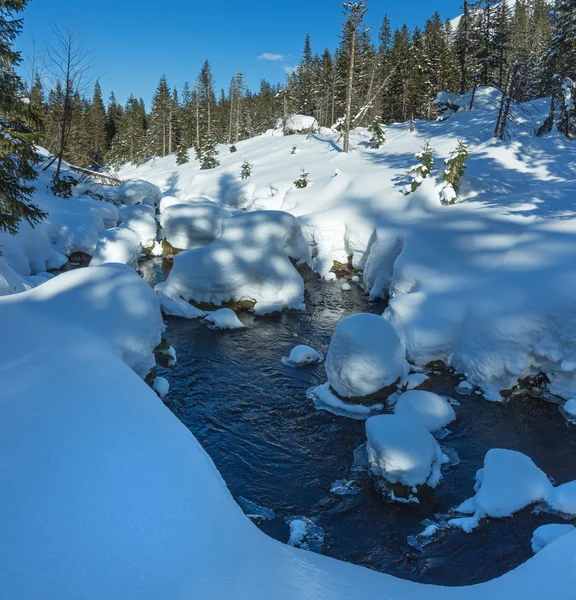 Piccolo ruscello di montagna con cumuli di neve . — Foto Stock