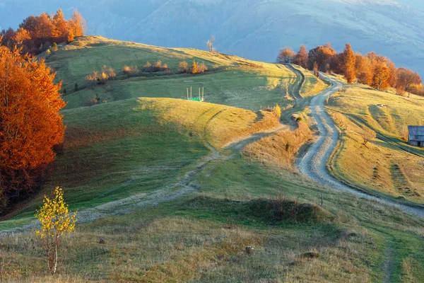 Wiejskiej drodze na stoku góry jesień. — Zdjęcie stockowe