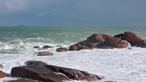 Vagues se brisant sur les rochers côtiers en pierre rose . — Video