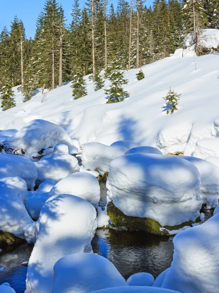 Pequeno córrego de montanha com snowdrifts . — Fotografia de Stock