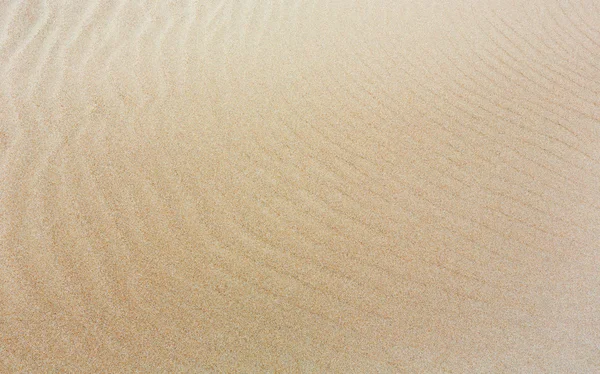 Sand background with barely visible waves. — Stock Photo, Image