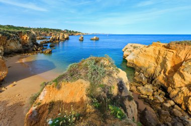 Sarı kayalıklarla plaj (Algarve, Portekiz).