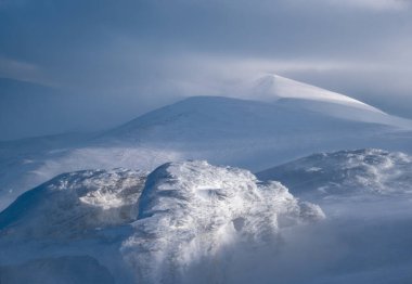 Kar dün akşam güneş ışığında kış dağlarını kapladı. Resimli alp kayak merkezinin tepesinde muhteşem rüzgarlı bir alacakaranlık.