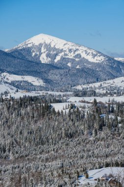 Kış uzak dağlık köyler, kırsal tepeler, ağaçlar ve dağ yamacından görünen tarım arazileri.