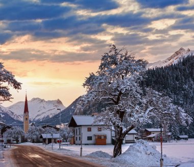 Kış akşam dağ köyü görünümü ve karlı ağaçlar (Avusturya, Tyrol).