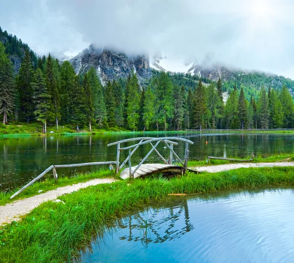 Alpiene zomer lake en zonneschijn via bewolkte hemel — Stockfoto