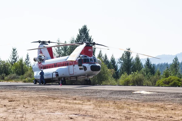 Chinook helicopter and fire crew — Stock Photo, Image