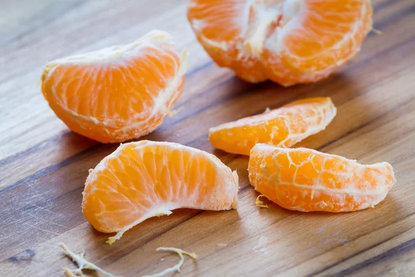 Bir kesme tahtası üzerinde soyulmuş portakal — Stok fotoğraf
