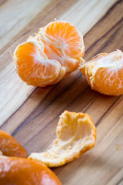 Laranja descascada em uma placa de corte — Fotografia de Stock