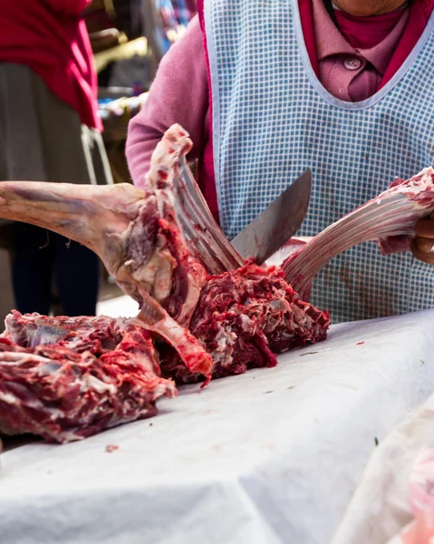 Butcher cutting meat in an open air market — Stock Photo, Image