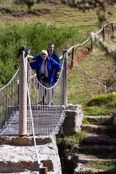 Touristes traversant un pont suspendu — Photo