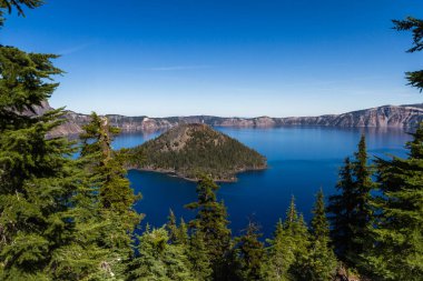 Beautiful perspective fro the rim of Crater Lake National Park, with wizard island contrasting against the deep blue water clipart