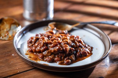 Bir kutu soğuk ve üzerinde soğuk fasulye olan bir tabak yenmeye hazır.