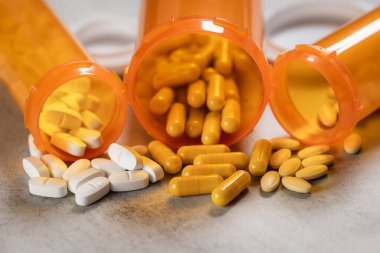 Tezgahta portakal reçetesi şişeleri ve hapları gösteren temiz bir fotoğraf..