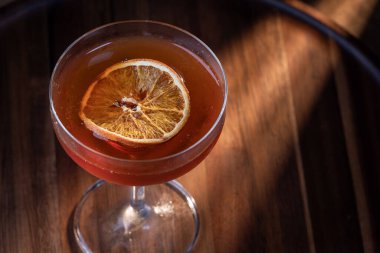 Viski kokteyli veya Manhattan kurutulmuş portakal dilimiyle süslenmiş..