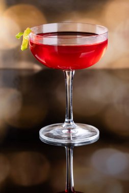 Güzel kozmopolit kokteyli limon kıvrımı ve dramatik ışıklandırmayla süslenmiş.