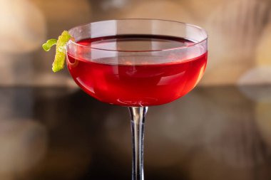 Güzel kozmopolit kokteyli limon kıvrımı ve dramatik ışıklandırmayla süslenmiş.