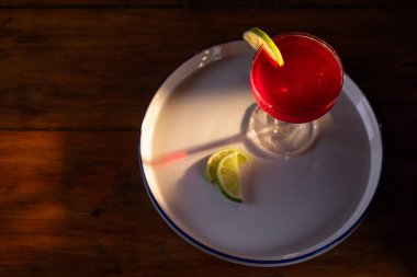 Güzel kozmopolit kokteyli limon dilimiyle süslenmiş dramatik ışıklandırmayla.