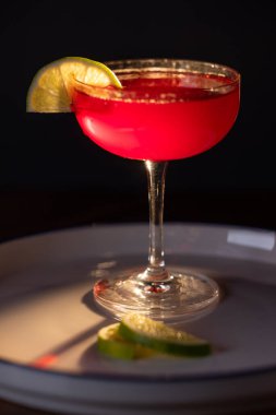 Güzel kozmopolit kokteyli limon dilimiyle süslenmiş dramatik ışıklandırmayla.