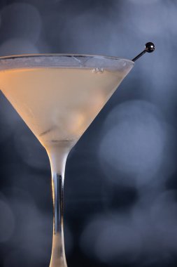 Buz gibi Gibson Martini bardan düşerken dramatik gölgeler ve ılık tonlarla