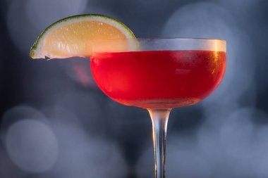 Güzel kozmopolit kokteyli limon dilimiyle süslenmiş dramatik ışıklandırmayla.